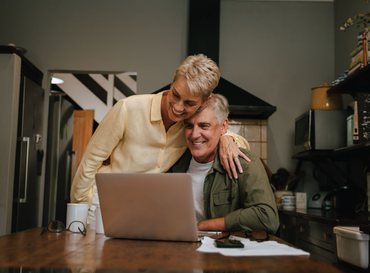 Older couple working together on laptop