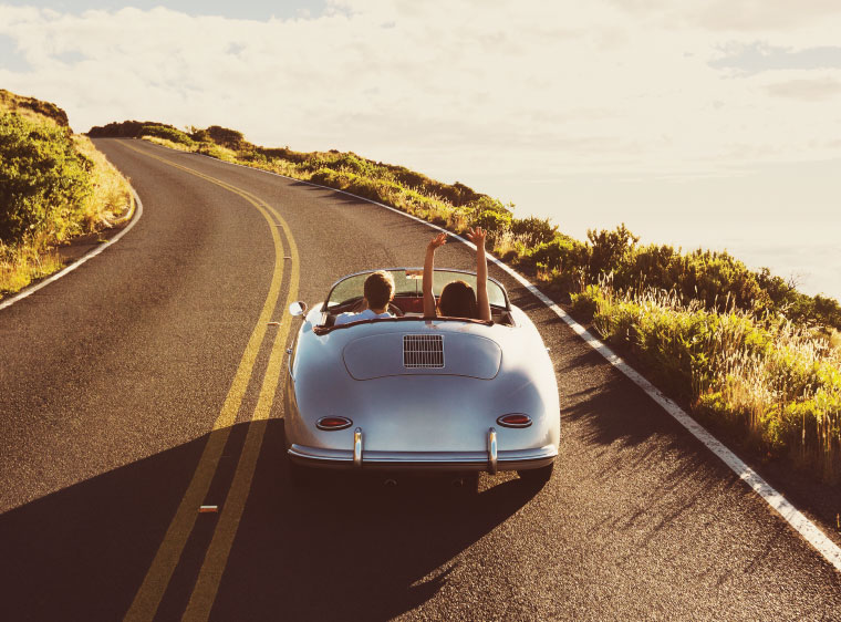 couple driving older collectible car