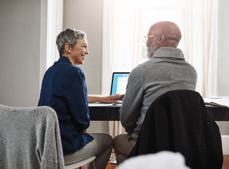 Older couple reviewing plans on laptop
