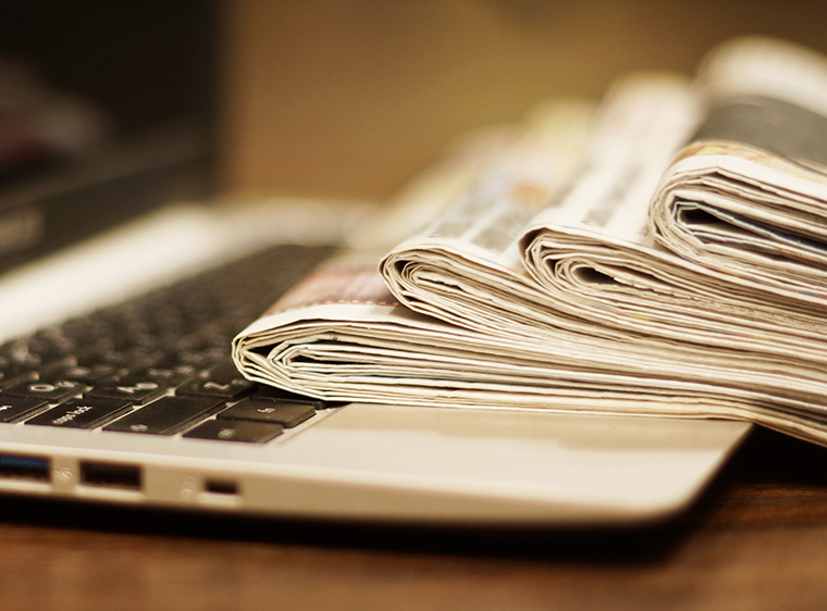laptop with newspapers on it