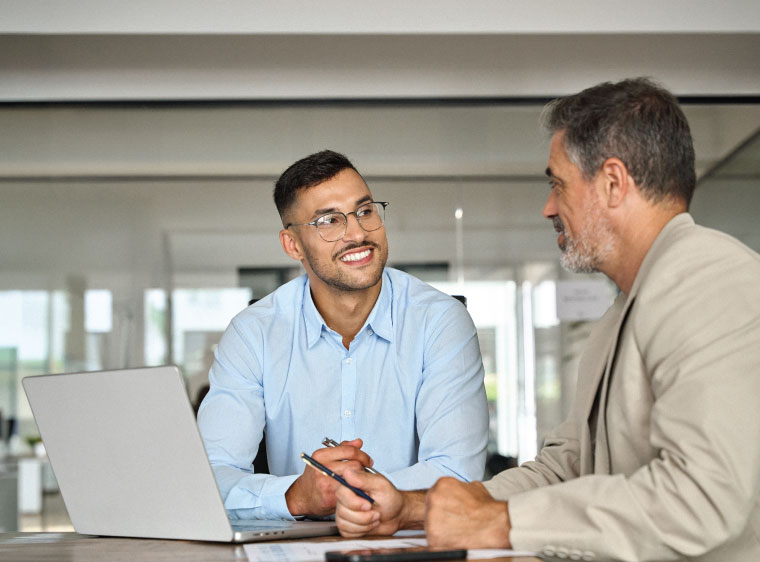 Two men working at laptop
