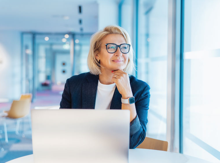 Older woman at laptop contemplating retirement